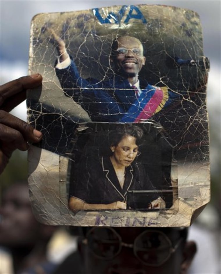 A man holds a picture of Haiti's ousted President Jean-Bertrand Aristide and his wife, Mildred Trouillot Aristide, during a protest Friday in Port-auPrince, Haiti.